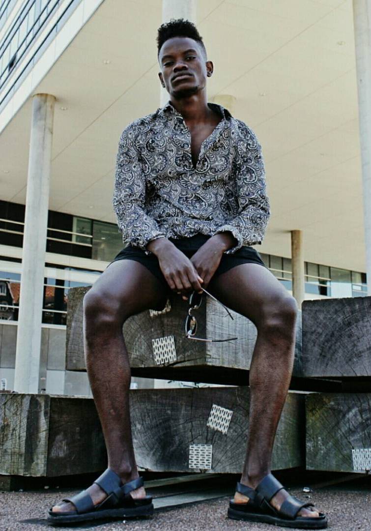 Man in patterned shirt sitting on wooden blocks