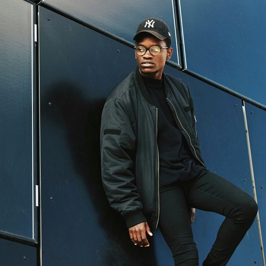 Portrait of a man leaning against a blue wall