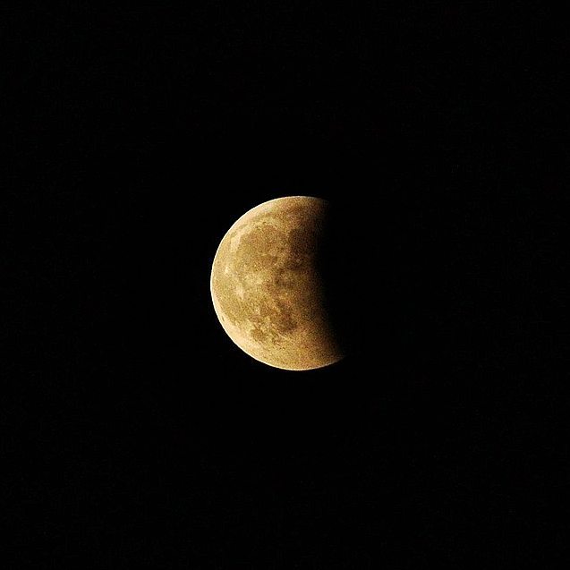 Partially shadowed moon in a dark sky
