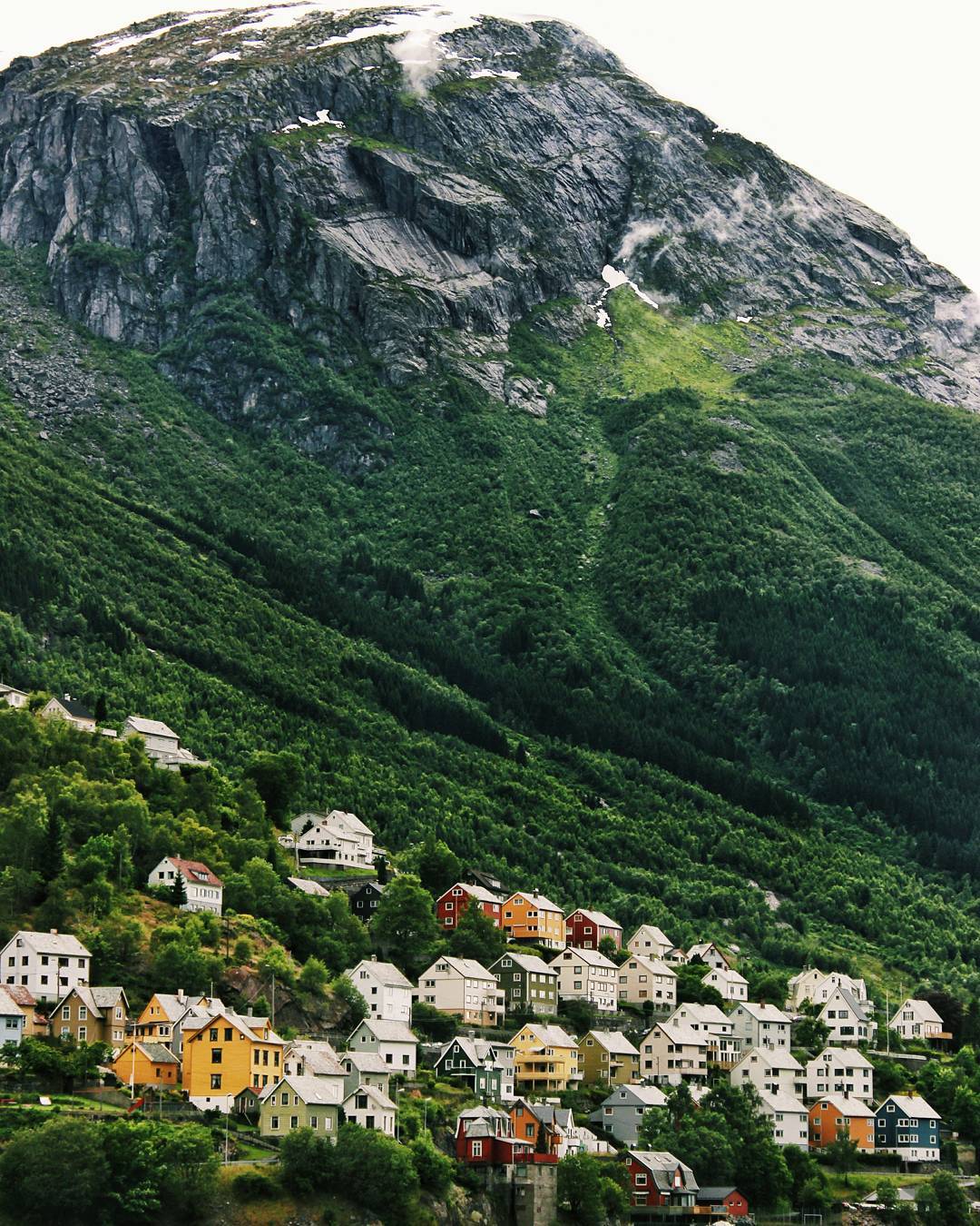 Colourful houses beneath a steep mountain