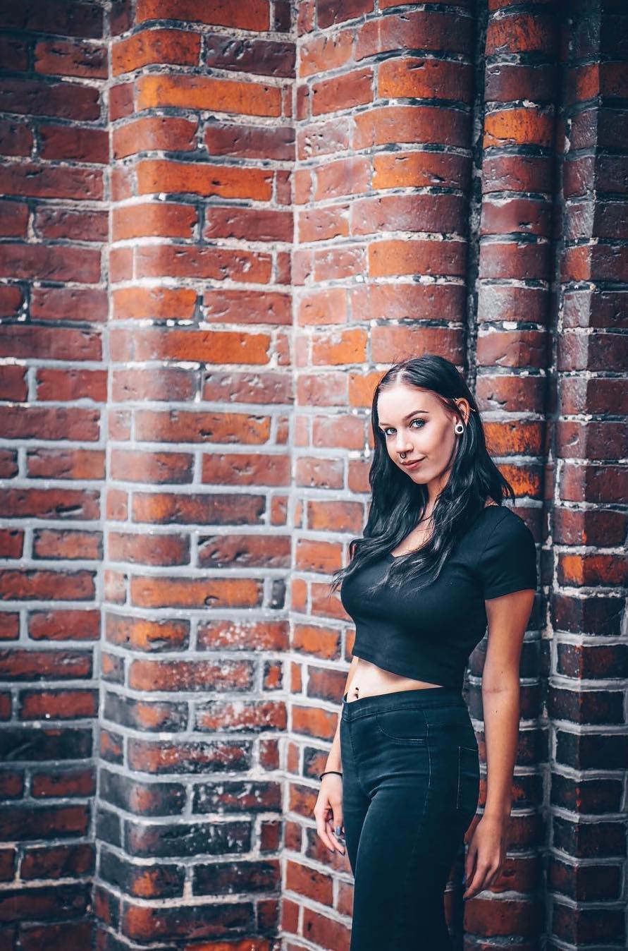 Woman standing against a red brick wall